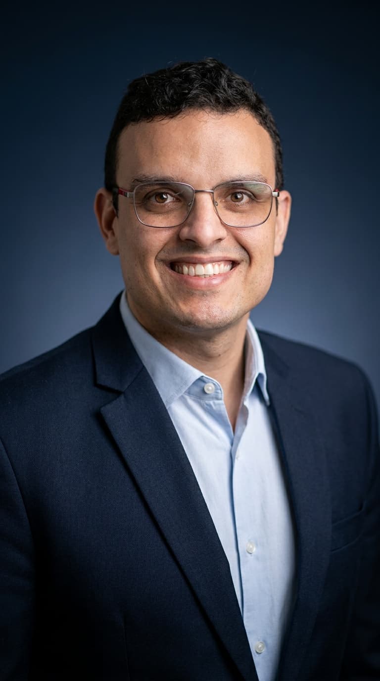 Dr. Patrick Medrado sorrindo, de terno azul-marinho